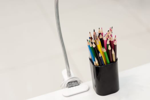 Many crayons with different colors. Back to school. Colored pencils in an glass.