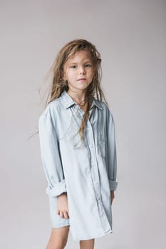 Stylish young teen girl posing at studio over gray background