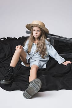 Stylish young teen girl posing at studio over gray background