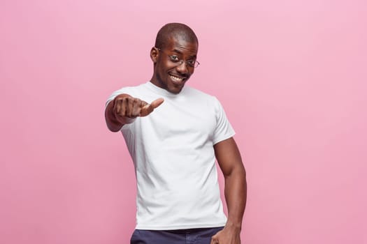 Portrait of a very happy afro american man showing thumbs up in studio on pink background