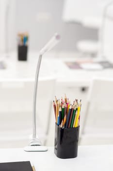 Many crayons with different colors. Back to school. Colored pencils in an glass.