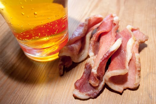 Board with home beef jerky - dried spicy meat, a large glass of beer.