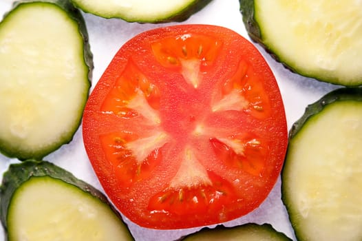 image of tomato slices and cucumber in a section. Natural background with slices of tomato. close-up, macro.