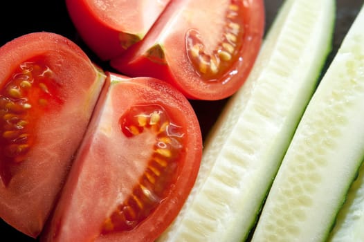 image of tomato slices and cucumber in a section. Natural background with slices of tomato. close-up, macro.