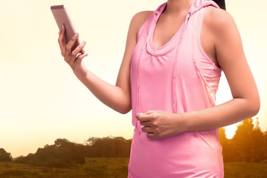 Close-up of asian sporty woman using mobile phone on the park