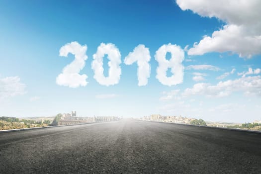 Asphalt road to the city with clouds make 2018 number. Happy New Year 2018