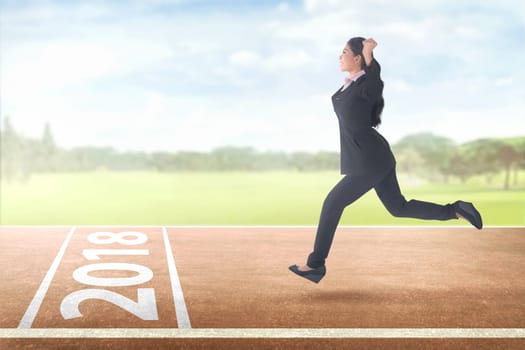 Happy asian business woman running with 2018 on finish line. Happy New Year 2018