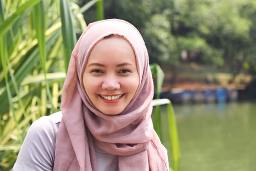 Young asian muslim woman in hijab with smiley face on the park