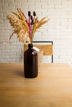 Dried flowers in a vase on wooden table, stock photo