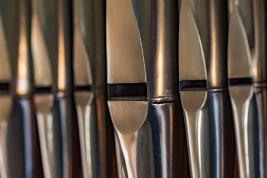 Close-up of organ pipes made of lead sheet metal standing in a row in a church