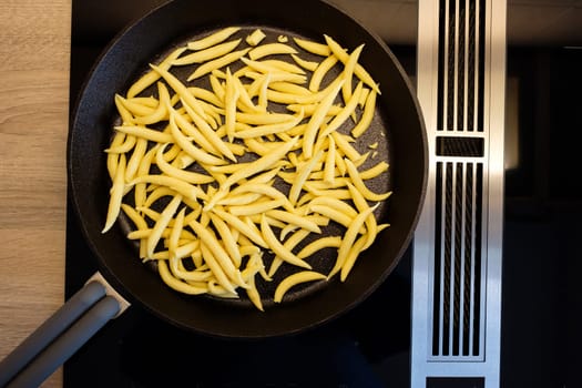 Raw Schupfnudeln in a frying pan on the stove in top view