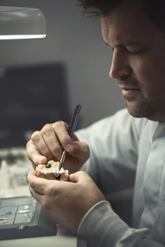 Dental prosthesis, artificial tooth, prosthetic, hands working on the denture, false teeth.