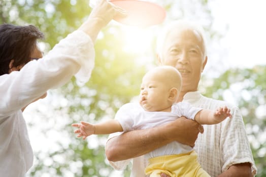 Grandparents taking care of baby grandchild in outdoor park. Asian family, life insurance concept.