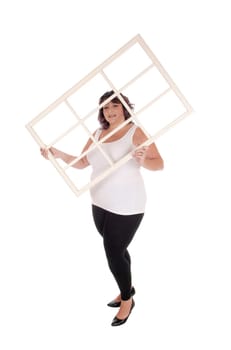An oversized woman in her forties standing in a white t-shirt and.tights  holding up an window frame, isolated for white background.