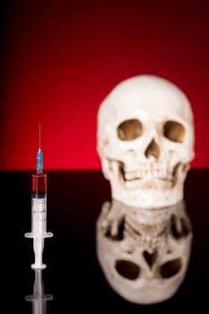 Blurry Skull and syringe, isolated on black red background with glossy reflection