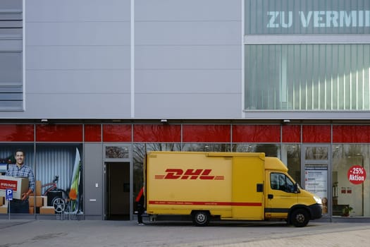 Mainz,Germany - November 14,2017: A parcel deliverer and delivery vehicle from DHL deliver parcels on November 4,2017 in Mainz.
