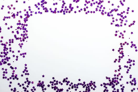 Purple glitter stars on a white background with copy space