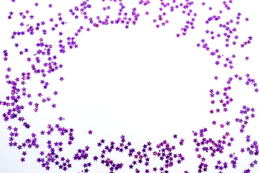 Purple glitter stars on a white background with copy space