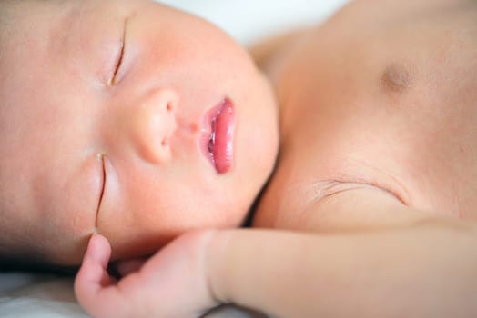 Little Asian newborn baby boy 1 week old, sleeps.