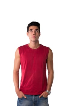 Attractive young man in red sleeveless shirt and jeans, looking up, isolated on white