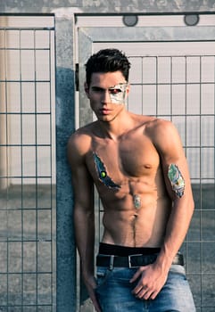 Young Handsome Shirtless Robot Man or Cyborg in the Street Showing Sexy Body Abs While Looking at Camera