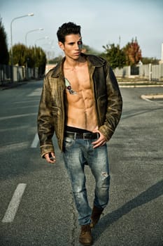 Young Handsome Robotic Man Wearing Leather Jacket Walking in the Street Showing Sexy Body Abs While Looking away