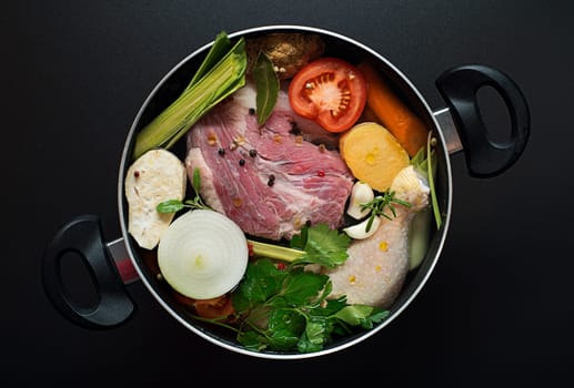 Fresh ingredients chicken and beef soup in a large pot