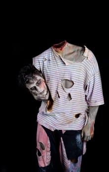 Decapitated zombie holding his own head under his arm