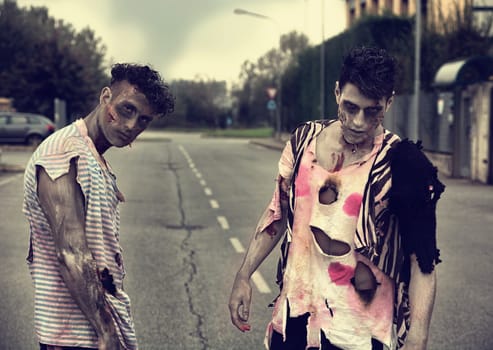 Two male zombies standing in empty city street looking at camera