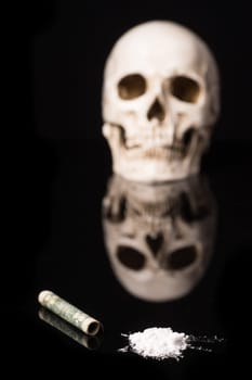 cocaine or other illegal drugs that are sniffed by means of a tube and Skull, isolated on black glossy background