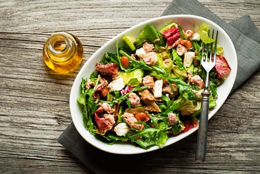 Tuna salad with lettuce beans and cheese on wooden table