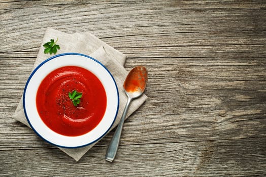 Fresh tomato soup on wooden background. Top view