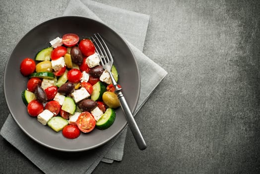 Salad with cheese and fresh vegetables on gray background. Greek salad.