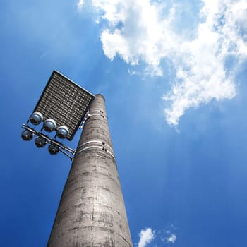 Floodlight with bounce panel for light, installed on an industrial chimney.