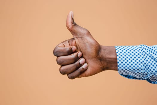 Hand showing OK sign isolated on brown background. Close-up of positive gesture, like, agreement, accept concept concept