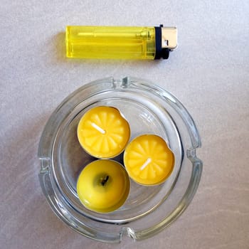 aerial view of three little yellow aromatic candles with a yellow lighter