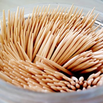 close up of a group of bamboo toohtpicks in a glass jar