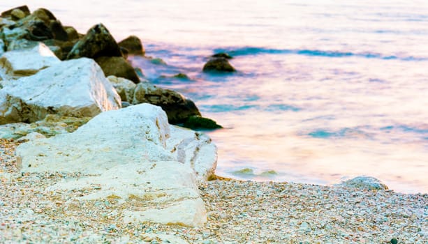 Stony beach and sea on a warm sunrise