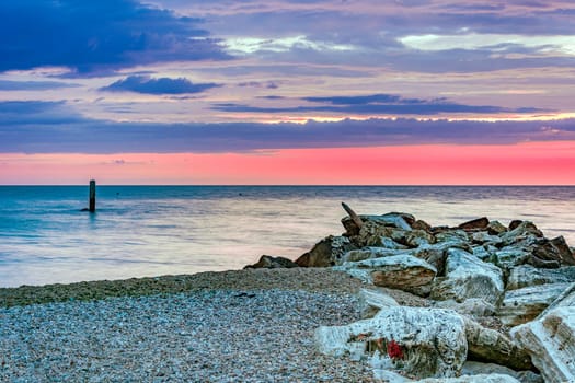 stony coastline with a cloudy  sunrise