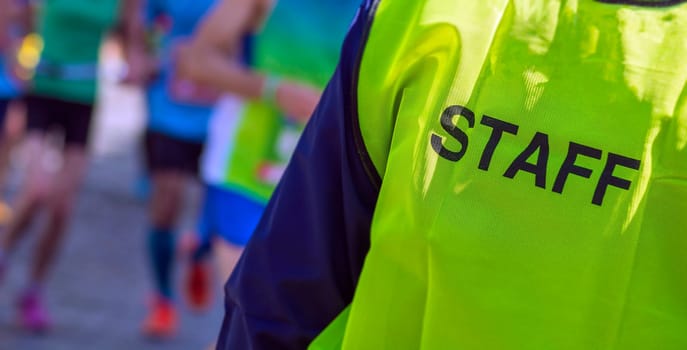 yellow bib staff service working during a marathon