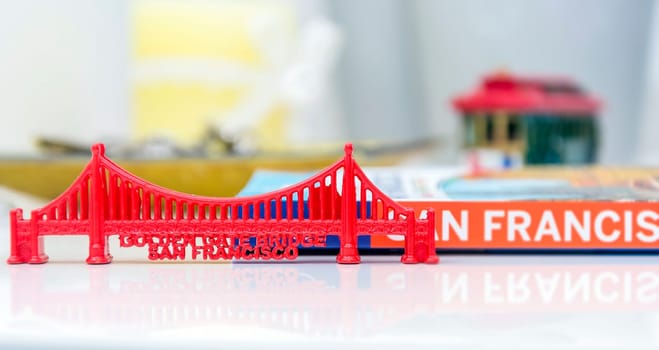 Golden Gate Bridge miniature with San Francisco city guide and a blurred cable car miniature in background