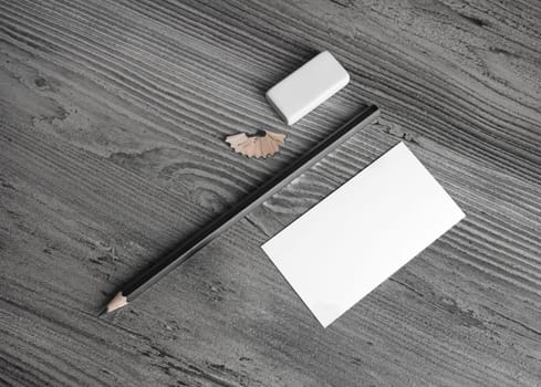 Blank stationery set. Business card, pencil and eraser on wood background. Top view.