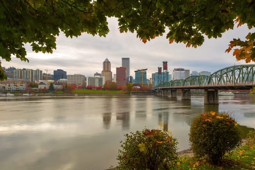 Portland Oregon downtown city skyline framed by fall season foliage along Willamette River