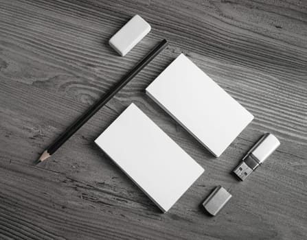 Blank stationery elements. Business cards, pencil, eraser and usb flash drive on wood background. Responsive design mock up. Top view.