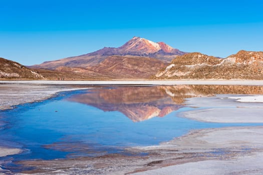 Volcano Cerro Tunupa with reflection in the Salar de Uyuni,Altiplano,3670 m above sea level,Bolivia,South America