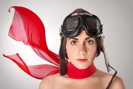 Beautiful girl with freckles wearing helmet, goggles and a red scarf