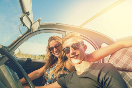 Young couple in a retro car at sunset, retro style.