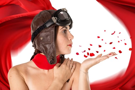 Beautiful girl with helmet and goggles blowing some rose petals