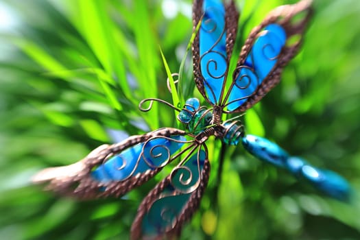 Artificial decorative butterfly in a plant, creative blur effect
