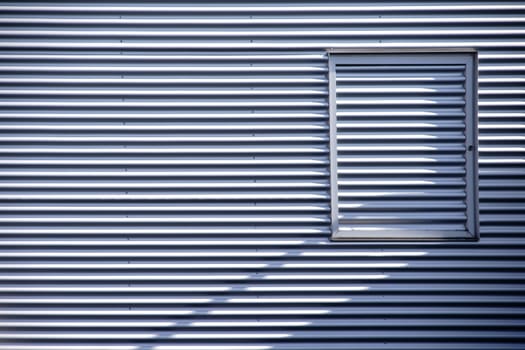 The detail of a modern façade made of corrugated sheet metal with a window frame.